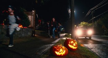 Movie still from “Diary of a Wimpy Kid” (2010), directed by Thor Freudenthal – Two jack o ' lanterns sitting on the side of the road; Wide shot, High angle