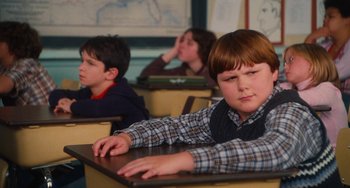 Movie still from “Diary of a Wimpy Kid” (2010), directed by Thor Freudenthal – Three boys are sitting at a desk in a classroom; Medium shot, Over the shoulder angle