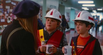 Movie still from “Diary of a Wimpy Kid” (2010), directed by Thor Freudenthal – A group of people wearing hard hats and holding cups; Medium shot, Over the shoulder angle