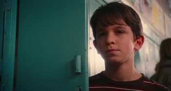 Movie still from “Diary of a Wimpy Kid” (2010), directed by Thor Freudenthal – A young boy standing in front of a green door; Close Up shot, Low angle