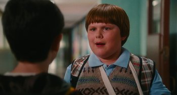 Movie still from “Diary of a Wimpy Kid” (2010), directed by Thor Freudenthal – A young boy wearing a blue shirt and a brown vest; Medium shot, Over the shoulder angle