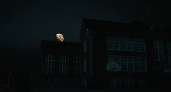 Movie still from “Diary of a Wimpy Kid” (2010), directed by Thor Freudenthal – A building with a basketball hoop in front of it and a moon in the background; Extreme Wide shot, Low angle