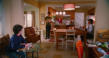 Movie still from “Diary of a Wimpy Kid” (2010), directed by Thor Freudenthal – A man and woman in a kitchen and living room; Wide shot, Over the shoulder angle