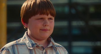 Movie still from “Diary of a Wimpy Kid” (2010), directed by Thor Freudenthal – A young boy with brown hair wearing a checkered shirt; Close Up shot, Over the shoulder angle
