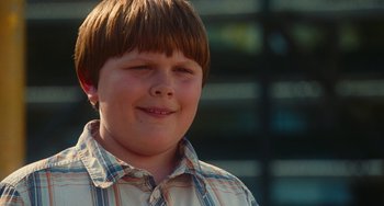 Movie still from “Diary of a Wimpy Kid” (2010), directed by Thor Freudenthal – A person wearing a plaid shirt smiling; Close Up shot, Over the shoulder angle