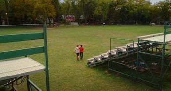 Movie still from “Diary of a Wimpy Kid” (2010), directed by Thor Freudenthal – Two young boys walking across a field towards a bleachers; Extreme Wide shot, High angle