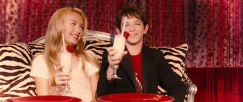 Movie still from “Diary of a Wimpy Kid: Rodrick Rules” (2011), directed by David Bowers – A boy and a girl sitting at a table with a glass of milk; Medium shot, High angle