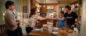 Movie still from “Diary of a Wimpy Kid: Rodrick Rules” (2011), directed by David Bowers – Two people standing at a kitchen table in a kitchen; Medium shot, Over the shoulder angle