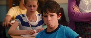 Movie still from “Diary of a Wimpy Kid: Rodrick Rules” (2011), directed by David Bowers – A boy and a girl sitting at a table with papers in front of him; Close Up shot, Over the shoulder angle