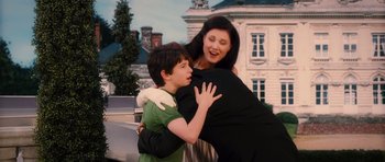 Movie still from “Diary of a Wimpy Kid: Rodrick Rules” (2011), directed by David Bowers – A woman and a boy hugging each other in front of a building; Medium shot, Over the shoulder angle