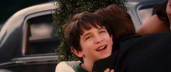Movie still from “Diary of a Wimpy Kid: Rodrick Rules” (2011), directed by David Bowers – A young boy is hugging his mother outside; Close Up shot, Over the shoulder angle
