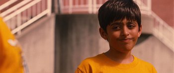 Movie still from “Diary of a Wimpy Kid: Rodrick Rules” (2011), directed by David Bowers – A young boy in a yellow t - shirt is looking at the camera; Close Up shot, Low angle