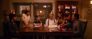 Movie still from “Diary of a Wimpy Kid: Rodrick Rules” (2011), directed by David Bowers – A group of people sitting around a table with a cake; Medium shot, Over the shoulder angle