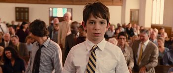 Movie still from “Diary of a Wimpy Kid: Rodrick Rules” (2011), directed by David Bowers – A boy in a white dress shirt and a yellow and blue striped tie; Close Up shot, Over the shoulder angle