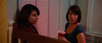 Movie still from “Diary of a Wimpy Kid: Rodrick Rules” (2011), directed by David Bowers – Two women are talking and drinking from cups; Medium shot, Over the shoulder angle