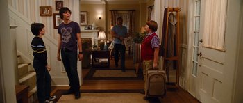 Movie still from “Diary of a Wimpy Kid: Rodrick Rules” (2011), directed by David Bowers – A group of young men standing in a room; Wide shot, Over the shoulder angle