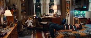 Movie still from “Diary of a Wimpy Kid: Rodrick Rules” (2011), directed by David Bowers – A person sitting on a bed with a stuffed animal; Wide shot, High angle