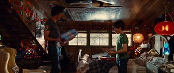 Movie still from “Diary of a Wimpy Kid: Rodrick Rules” (2011), directed by David Bowers – Two people standing in a room with boxes of toys; Medium shot, Over the shoulder angle