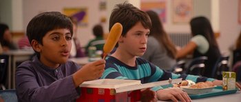 Movie still from “Diary of a Wimpy Kid: Rodrick Rules” (2011), directed by David Bowers – A boy holding a hot dog in his hand while sitting in front of another boy; Close Up shot, Over the shoulder angle