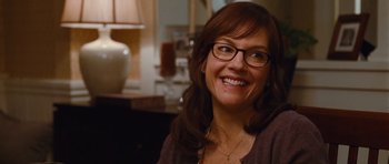 Movie still from “Diary of a Wimpy Kid: Rodrick Rules” (2011), directed by David Bowers – A woman wearing glasses and smiling for the camera; Close Up shot, Over the shoulder angle