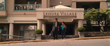 Movie still from “Diary of a Wimpy Kid: Rodrick Rules” (2011), directed by David Bowers – A couple of people standing in front of a building; Wide shot, Over the shoulder angle