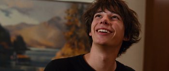 Movie still from “Diary of a Wimpy Kid: Rodrick Rules” (2011), directed by David Bowers – A young man smiling and looking up to the sky; Close Up shot, Low angle