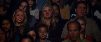 Movie still from “Diary of a Wimpy Kid: Rodrick Rules” (2011), directed by David Bowers – A group of people sitting in a room watching a show; Medium shot, Over the shoulder angle