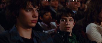 Movie still from “Diary of a Wimpy Kid: Rodrick Rules” (2011), directed by David Bowers – Two young men sitting in front of a group of people; Close Up shot, Over the shoulder angle