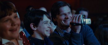 Movie still from “Diary of a Wimpy Kid: Rodrick Rules” (2011), directed by David Bowers – A man and a young boy smiling for the camera; Close Up shot, Over the shoulder angle