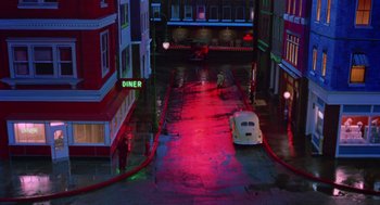 Movie still from “Dick Tracy” (1990), directed by Warren Beatty – A street scene with neon lights and a diner sign lit up at night; Extreme Wide shot, High angle
