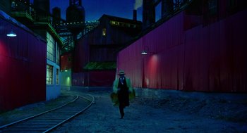 Movie still from “Dick Tracy” (1990), directed by Warren Beatty – A man walking down a street at night; Extreme Wide shot, High angle