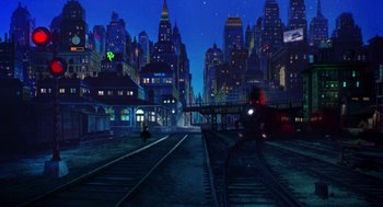 Movie still from “Dick Tracy” (1990), directed by Warren Beatty – A train on the tracks in the middle of a city at night; Extreme Wide shot, High angle