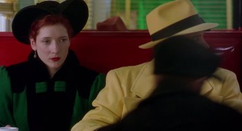Movie still from “Dick Tracy” (1990), directed by Warren Beatty – A woman sitting next to a man wearing a hat; Close Up shot, Over the shoulder angle
