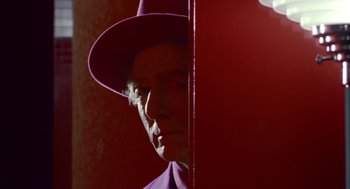 Movie still from “Dick Tracy” (1990), directed by Warren Beatty – A man wearing a purple hat and a purple jacket; Close Up shot, Over the shoulder angle
