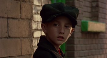 Movie still from “Dick Tracy” (1990), directed by Warren Beatty – A young boy wearing a green hat and jacket; Close Up shot, Low angle