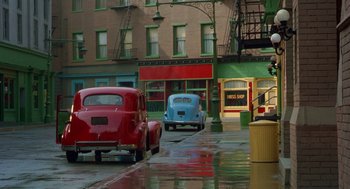Movie still from “Dick Tracy” (1990), directed by Warren Beatty – A street scene with a red and a light blue car; Wide shot, High angle