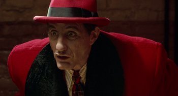 Movie still from “Dick Tracy” (1990), directed by Warren Beatty – A man in a red hat and a tie; Close Up shot, Low angle