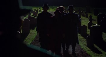 Movie still from “Dick Tracy” (1990), directed by Warren Beatty – A group of people walking through a cemetery at night; Wide shot, High angle