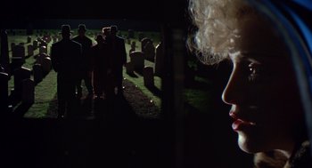 Movie still from “Dick Tracy” (1990), directed by Warren Beatty – A group of people standing in a field at night; Close Up shot, Over the shoulder angle