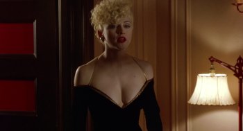 Movie still from “Dick Tracy” (1990), directed by Warren Beatty – A woman in a black dress with blonde curly hair; Close Up shot, Over the shoulder angle