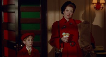 Movie still from “Dick Tracy” (1990), directed by Warren Beatty – A woman in a red trench coat holding a bowl of ice cream; Medium shot, Over the shoulder angle