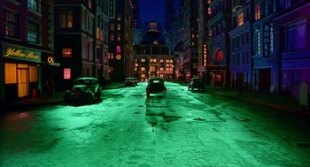 Movie still from “Dick Tracy” (1990), directed by Warren Beatty – A street scene with cars parked on the side of the road; Extreme Wide shot, Low angle