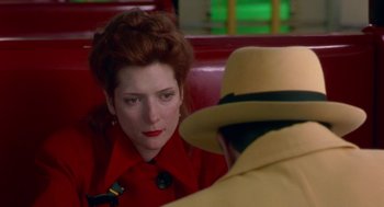 Movie still from “Dick Tracy” (1990), directed by Warren Beatty – A woman in a red coat and a man in a yellow hat; Close Up shot, Over the shoulder angle