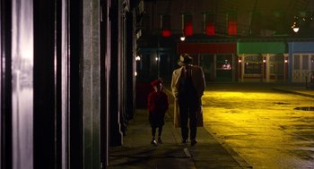 Movie still from “Dick Tracy” (1990), directed by Warren Beatty – A man and a child walking down a street at night; Wide shot, High angle