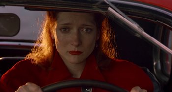 Movie still from “Dick Tracy” (1990), directed by Warren Beatty – A woman in a red jacket driving a car; Close Up shot, High angle