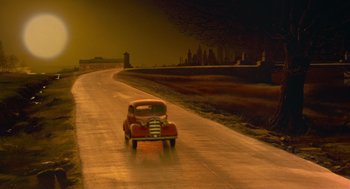 Movie still from “Dick Tracy” (1990), directed by Warren Beatty – An old car is driving down the street; Extreme Wide shot, High angle