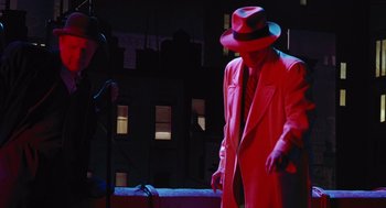 Movie still from “Dick Tracy” (1990), directed by Warren Beatty – A man in a red coat and a hat; Wide shot, High angle