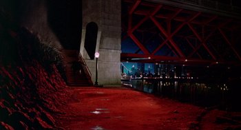 Movie still from “Dick Tracy” (1990), directed by Warren Beatty – A view of a city at night from under a bridge; Extreme Wide shot, High angle