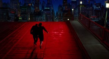 Movie still from “Dick Tracy” (1990), directed by Warren Beatty – Two people are walking on a red sidewalk at night; Extreme Wide shot, High angle