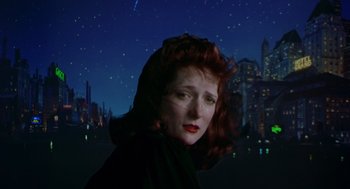 Movie still from “Dick Tracy” (1990), directed by Warren Beatty – A woman with red hair standing in front of a night sky; Close Up shot, Low angle